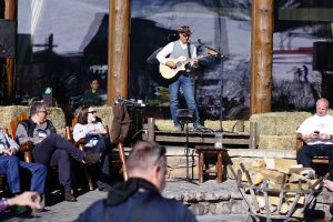 An individual performer sets the stage for an acoustic après ski on a sunny patio. Photo by Jensen Sutta. 