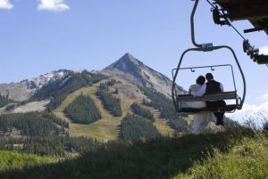 Bride and groom on a summer chairlift ride up to a mid-mountain wedding venue. Courtesy Crested Butte Mountain Resort.